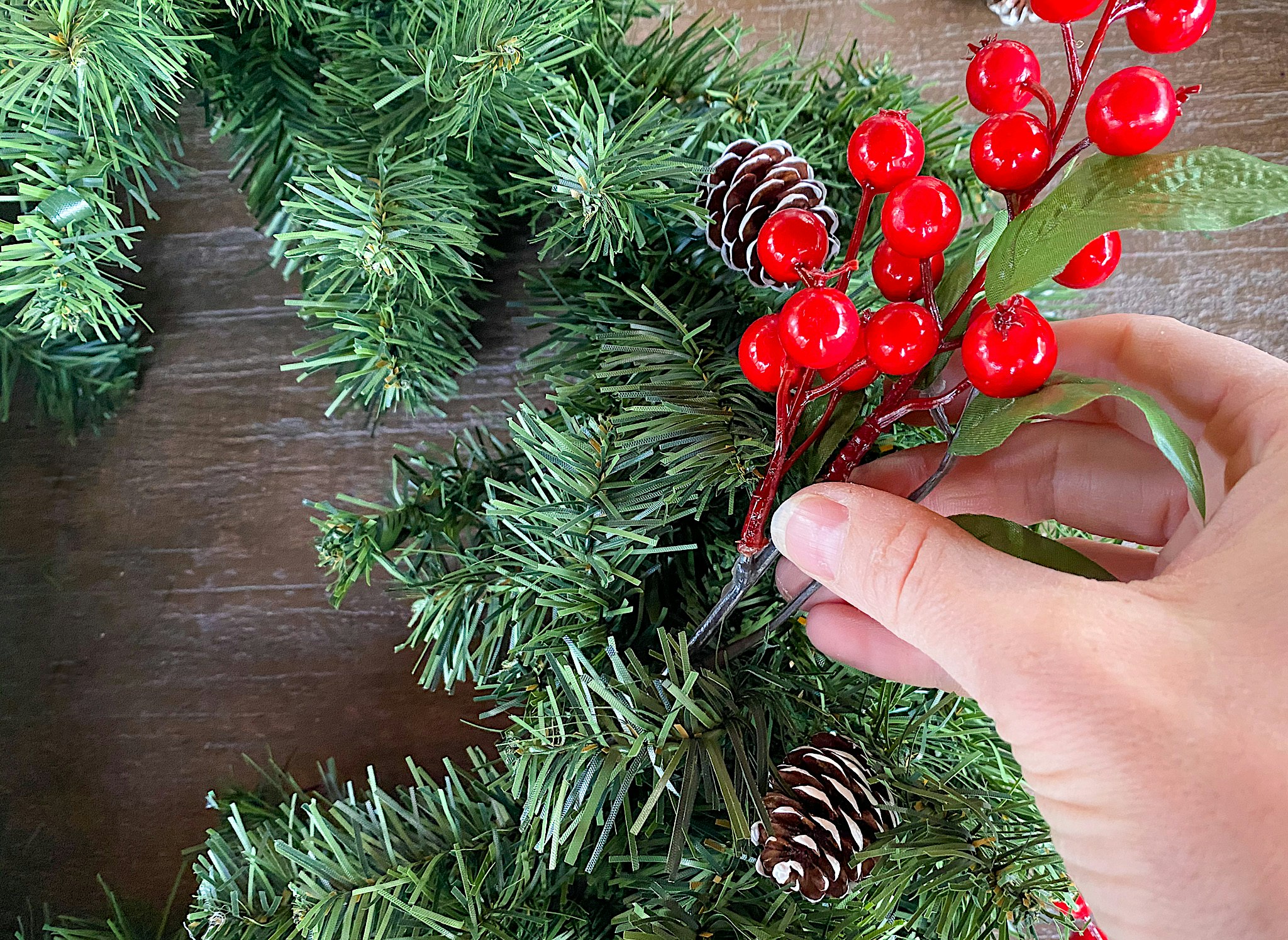 adding decorations to. a christmas wreath